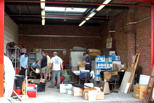 Team members start moving the packing crates and boxes in to the Bolton Fire Station Garage.